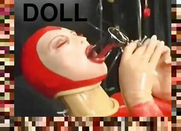 Sexy girl encased in red rubber catsuit loves medical games with mouth spreader and nipple clamps