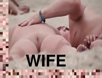 Masturbating his wife on the beach