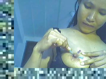 Webcam girl puts needles through her nipples