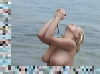 Chubby blonde with massive natural tits playing with her pussy on the beach