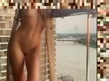 Naked woman on the balcony of a skyscraper. Nude in Public. Exhibitionist wife.