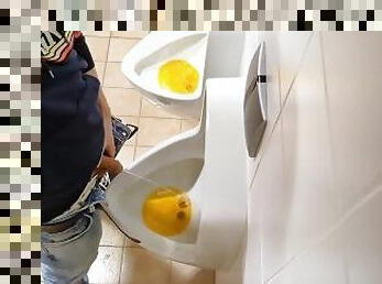 amateur guy pissing at public urinal